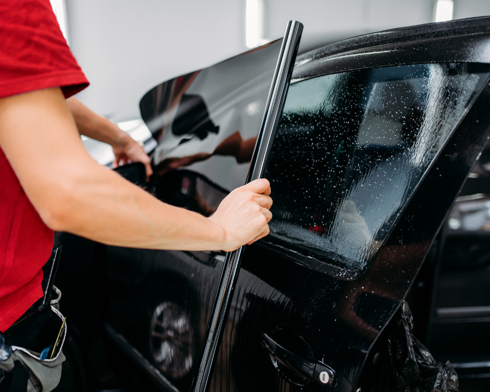 Cleaning the roll-down window and surrounding seals before interior tint application.